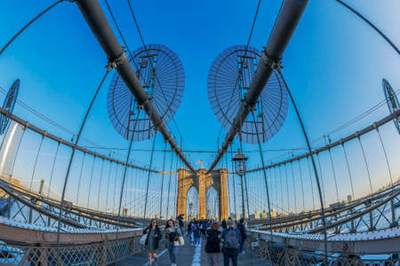 NEW YORK, USA - MARCH 9, 2020: Large angle view of Brooklyn bridge in afternoon light with tourists that crossing.のeditorial素材