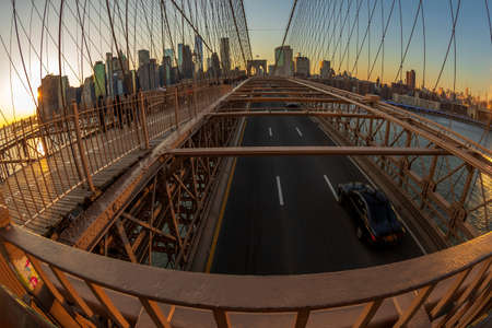 NEW YORK, USA - MARCH 9, 2020: Large angle view of Brooklyn bridge in afternoon light with tourists and traffic. Skyscrapers from Manhattan in the background.のeditorial素材