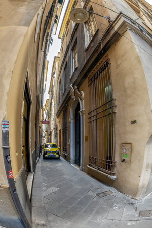 GENOA, ITALY - MARCH 20, 2021: Incredible car traffic on the super narrow streets of the historic...