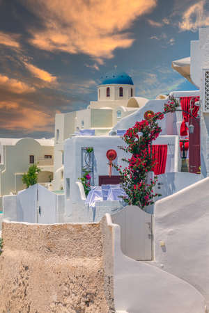 Typical traditional architecture with decorated houses, domes and churches in afternoon light. Oia, Santorini island, Greece.の写真素材