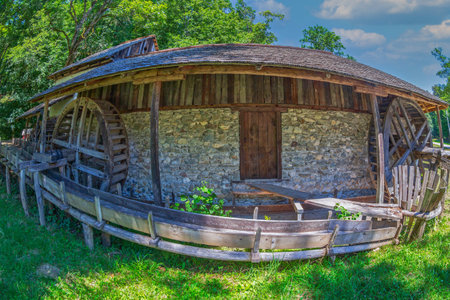 SIBIU, ROMANIA - JULY 9, 2020: Old traditional romanian watermill with Two Filling Cylinders and Two Whirlpools. Museum of Traditional Popular Civilization, the largest open-air museum in Romania.のeditorial素材