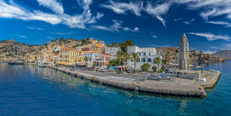 SYMI, GREECE - JULY 3, 2022: Symi harbour, with colorful neoclassical mansions covering the slopes...
