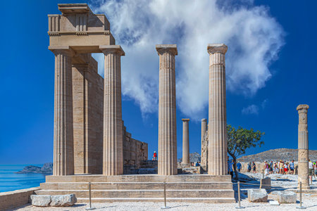 LINDOS, RHODES island, GREECE-JULY 1, 2022: Ruins of ancient Temple of Athena Lindia on Acropolis of Lindos, built in the 4th century BC in amphiprostyle with four Doric columns at the front and back.のeditorial素材
