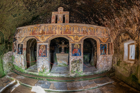 Village of Jgheaburi,Corbi commune,ArgeÈ county,Romania - Sept. 16, 2022: Interior of the Stone Crows Monastery (Corbii de Piatra).Excavated in the rock wall 30 m high and 14.5 m long in 14th century.の写真素材