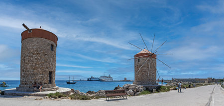 RHODES, GREECE-JUNE 29,2022:Medieval Rhodes Town Windmills, in Mandraki harbor. They are one part of the 13 windmills which were located on the pierand and dating from the time of the Great Masters.のeditorial素材