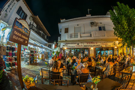 SKIATHOS TOWN, SKIATHOS ISLAND, GREECE - AUGUST 22, 2023: Evening view of the narrow streets, full of traditional taverns, in the Greek Mediterranean architecture of the old town.のeditorial素材