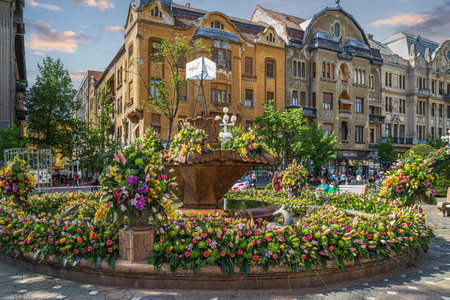 TIMISOARA, ROMANIA - APRIL 27, 2018: Floral decorations in Victory Square on the occasion of the Flower Festival organized by the City Hall. Old fountain is support.のeditorial素材