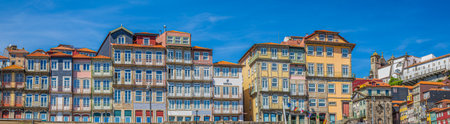 PORTO, PORTUGAL - APRIL 11, 2024: Panoramic view with old multi-colored houses and traditional facades, in old town pier architecture over Douro river. Porto Ribeira, along da Cais da Ribeira.のeditorial素材