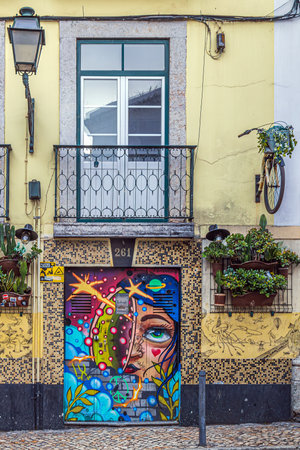 LISBON, PORTUGAL - APRIL 7, 2024: Funny street decorations, with bicycle parts, graffiti and street paintings on the facades of houses in Rua da Rosa street.のeditorial素材