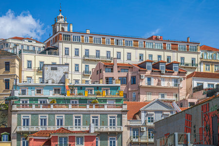 LISBON, PORTUGAL - APRIL 7, 2024: Panoramic view with old multicolored houses and traditional facades, placed in steps on a hill in the old town.のeditorial素材