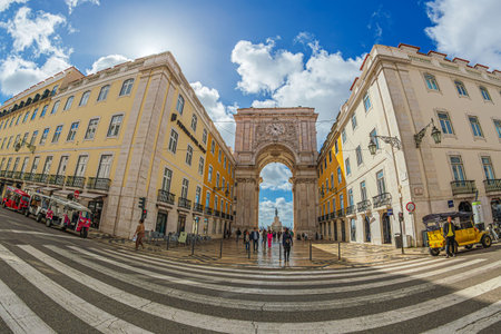 LISBON, PORTUGAL - APRIL 7, 2024: View of Bilheteira Arco da Augusta from the intersection of R. Augusta with R. do Comercio. Touristic TUK-TUK cars waiting for customers.のeditorial素材