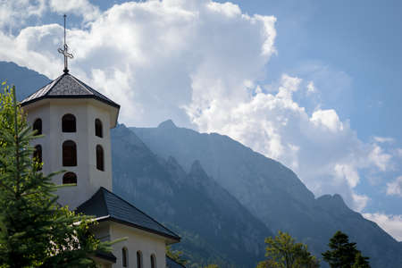 Church tower with mountains in backgroundの写真素材