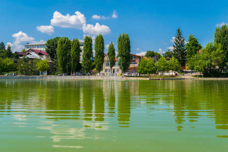 Campina, Romania - August 16, 2018: view of the cursed Bride's Lake or the Church Lake showing green trees and water fountain situated in Campina, Prahova, Romania.のeditorial素材