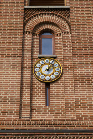 Beautiful old clock. Vintage golden roman numbers clock mounted at the exterior of an old brick...