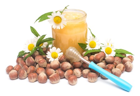 Honey in jar with mint, nuts and chamomile flower isolated on white background. Green pharmacy. Yellow, healthy food for health and sports. Vitaminsの写真素材