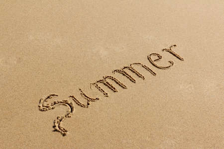 Summer - text written by hand on sand on a beach, positioned diagonallyの写真素材