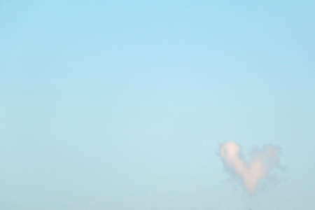 Cloud in the shape of heart on perfectly clear blue skyの写真素材