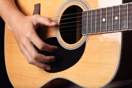 man playing on acoustic guitar