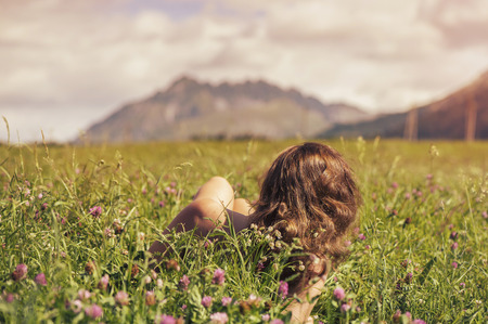 Naked female in a field at sunsetの写真素材