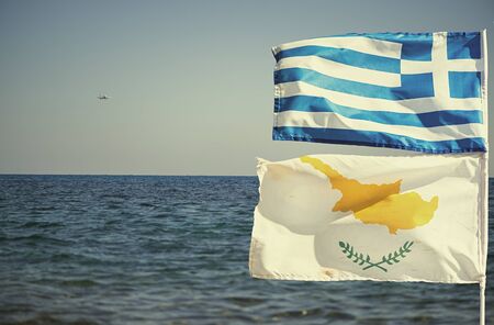 Greek and Cypriot flags on the background of the seaの写真素材
