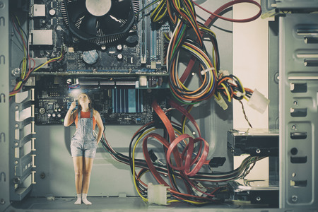 Little girl with a flashlight inside a large computer. Computer techologies.の写真素材