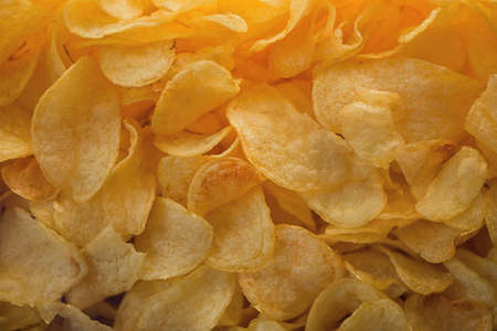 A lot of potatoes chips. Yellow salted potato chips as background. Chips texture.の写真素材