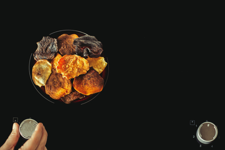 Vegetable chips lie on electric stove and cook. Preparation of vegetable and potato chipsの写真素材