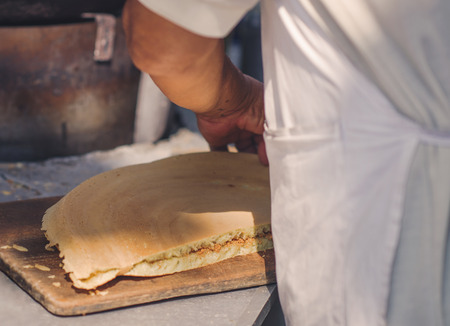 A man is cooking a pie in the market of chinatown, Malaysia. Street food.の写真素材
