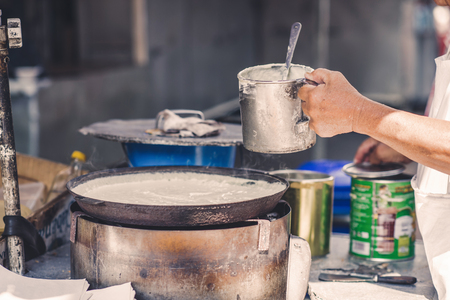 A man is cooking a pie in the market of chinatown, Malaysia. Street food.の写真素材