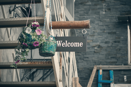 The inscription is welcome on the wooden plaque at the entrance of the old buildingの写真素材