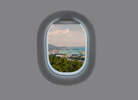 Panorama of the island of Mahe in the plane window. Tropical Seychelles in airplane window