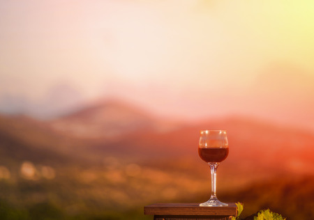 Glass of red wine on background sunset of natureの写真素材