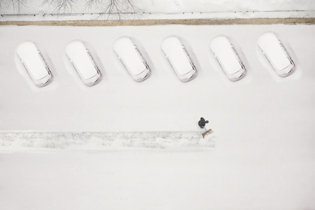 janitor cleans the snow-covered parking space during the snow season. Winter time.の写真素材