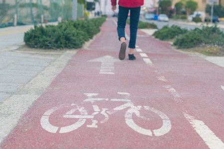Unfocused boy's legs on the road for bicycle at dusk.  Bicycle sign on the road used for pedestrian crossing bicycle lane. Conceptの写真素材