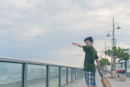 A boy in a T-shirt and shorts walks on the Finikoudes beach - Larnaca, Cyprus islandの写真素材