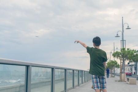 A boy in a T-shirt and shorts walks on the Finikoudes beach - Larnaca, Cyprus islandの写真素材