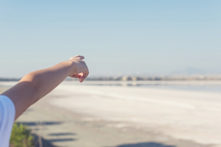 A boy finger shows on the salt lake in Larnaca. Cyprusの写真素材
