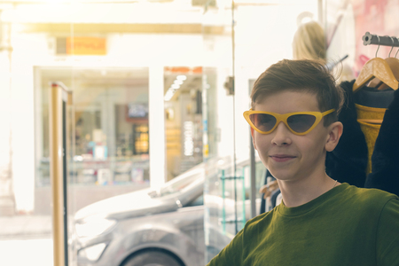 The boy is having fun and trying on sun glasses in the store.の写真素材