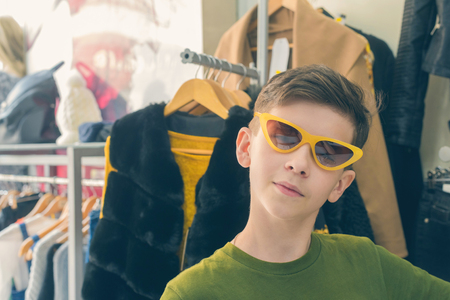 The boy is having fun and trying on sun glasses in the store.の写真素材