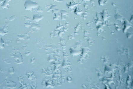 The texture of close up water of melted snowflake or frost on the glass. Winter background ant...