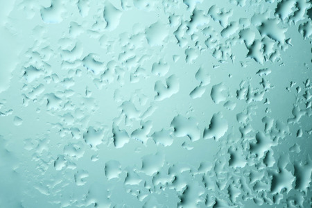 The texture of close up of aquamarine water drop of melted frost on the glass. Winter background ant texture.の写真素材