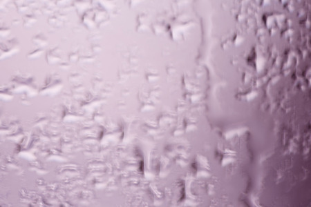 Blurred texture of close up of pink water drop of melted frost on the glass. Winter background ant texture.の写真素材
