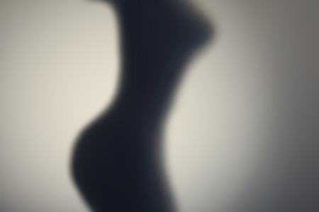 Silhouette of naked woman's body  behind glass door. Conceptの写真素材