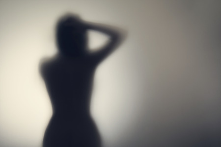 Silhouette of naked woman's body  behind glass door. Conceptの写真素材