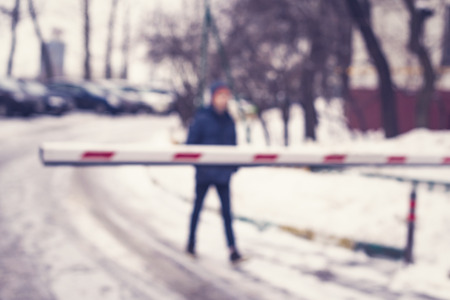 Blurred background of automatic car barrier gate security with teen boy. Conceptの写真素材