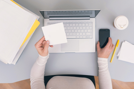Woman clerk in the office holding empty note sticker for any message. Concept. Space for textの写真素材