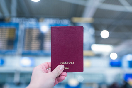 Female holding russian pasport opposite airport board.の写真素材