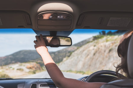 The girl is driving on the highway in Australia. View from the back seat of the car on the...