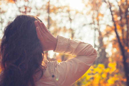 Female with headphones walking on the park listen sounds or music of autumn forest. Concept. Indian summer seasonの写真素材