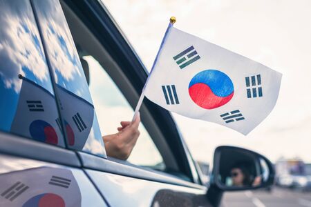 Woman or Girl Holding South Korea Flag from the open car windowの写真素材
